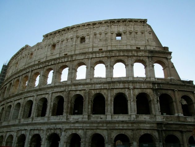 A close-up of a stone building with Colosseum in the background AI-generated content may be incorrect.